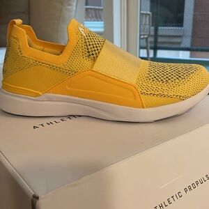 NIB | APL Women's Techloom Bliss Slip On Sneaker Marigold Yellow/Black/White 7.5